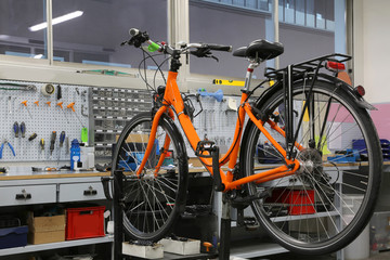 Fototapeta na wymiar bicycle repair workshop with one orange bike