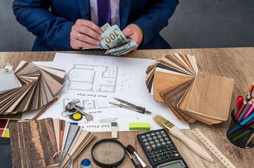 Designer counts the money for the work - house project.