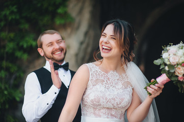 Happy newlyweds are laughing cheerfully. The bride is laughing at the joke.
