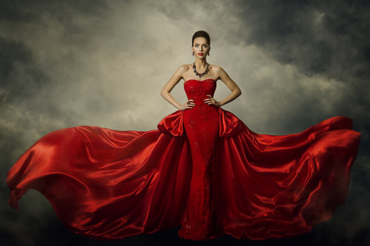 Fashion Model Art Dress, Elegant Woman Standing in Red Retro Gown, Silk Fabric Fluttering over Storm Sky Background