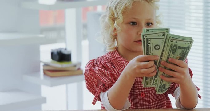 Kid as business executive counting currency note 