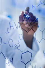 Chemical elements. Selective focus of chemical formulas being written on the transparent glass