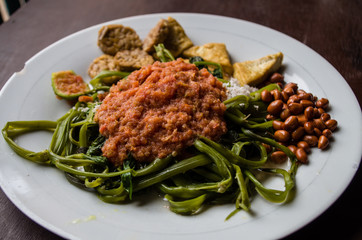 Indonesian dish kankung plecing (spicy water spinach dish) typical for Lombok island close up.