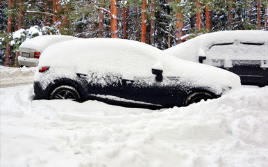 Beautiful winter landscape. Cars covered with snow after huge snowfall. Roads and vehicles hidden under snow.