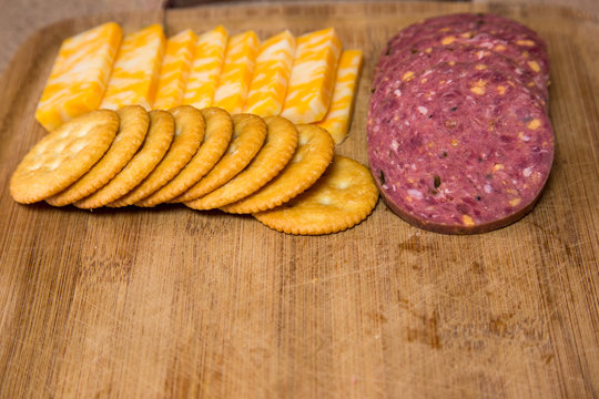 Venison Sausage Sliced With Colby Cheese Round Crackers On Cutting Board