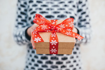 Girl holding a Christmas gift box with a red bow