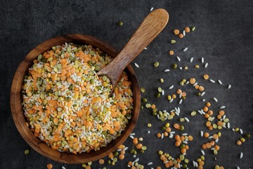 Overhead view of rice and different lentils on wooden bowl / Health Nutrition concept