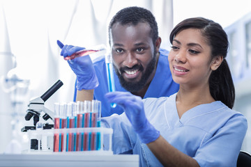 Scientific innovations. Positive smart enthusiastic scientists looking at the test tubes and...