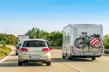 Cars and caravan with bicycles on road in Switzerland