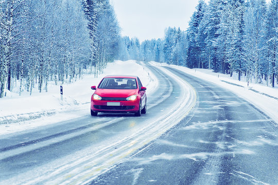 Red Car in road in winter Rovaniemi