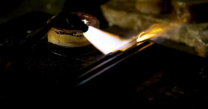 Welding torch is being used to melt jewellery in workshop 
