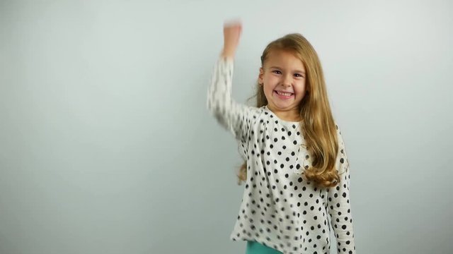 Funny young girl showing twice success gesture on the white background. Slow motion