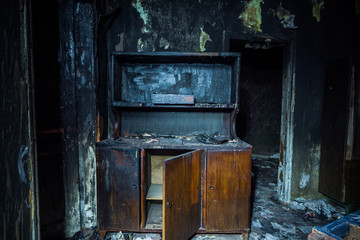 Consequences of fire. Interior of the burned by fire house, burned furniture 
