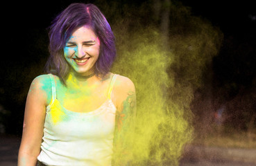 Joyful woman with purple hair having fun with dry Holi powder. Space for text