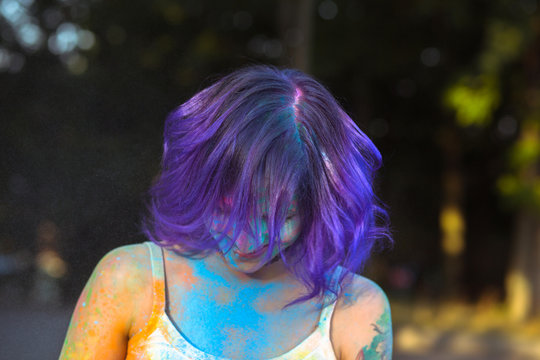 Closeup shot of woman with purple hair and covered with dry powder Gulal