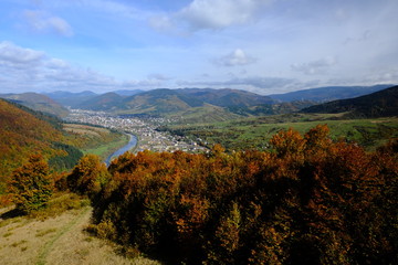 Mountain autumn landscape, view from ski elevator to small town or village