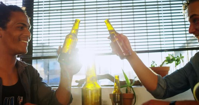 Male friends toasting beer bottles 