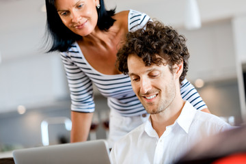 Couple at home using laptop