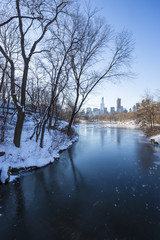 Wintry view of Central Park from the frozen lake with the urban skyline of the Upper West Side in Manhattan, New York City 