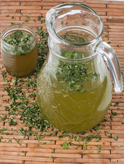 Moringa leaves with juice in a glass on wooden background