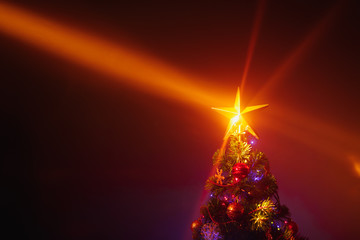 Christmas tree with festive lights, orange background with mist