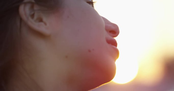 Woman turns head from sunset