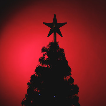 Christmas tree with festive star silhouette, red background