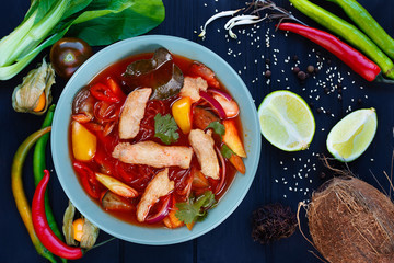 Appetizing red curry soup with chicken and rice noodles, flat lay. Pan-Asian, thai food, oriental cuisine