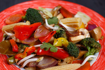 Tasty stir-fry vegetables mix with soybean sprouts and mushrooms, close up. Delicious vegetarian food, Pan-Asian, oriental cuisine