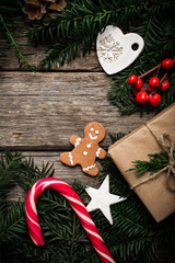 Christmas background with gingerbread, xmas tree and decoration on dark wooden board.