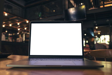 Mockup image of laptop with blank white screen on wooden table in modern loft cafe