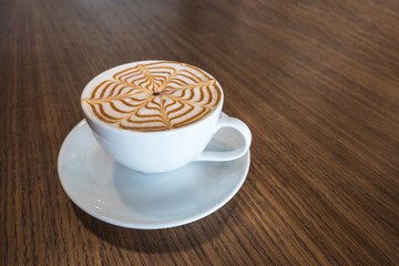 Cup of coffee latte art on wooden background