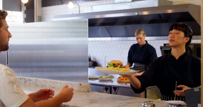 Waitress serving food to customer 