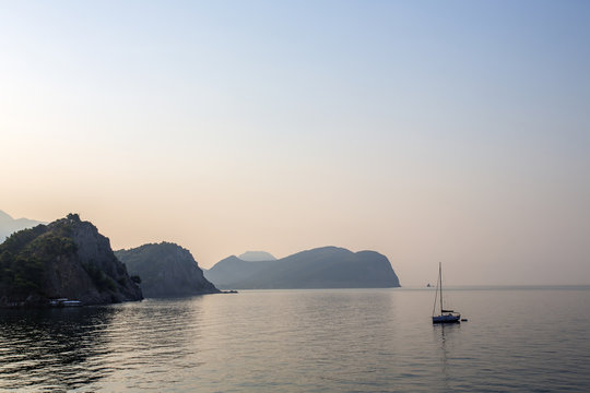 Far in the distance is a lonely boat and islands in the ocean