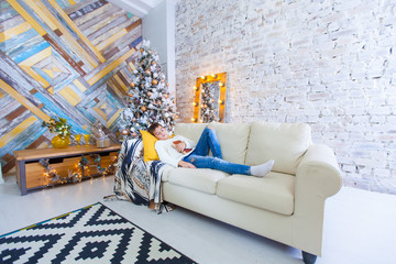 boy 10 years on the couch reading a Christmas book. Xmas holiday concept