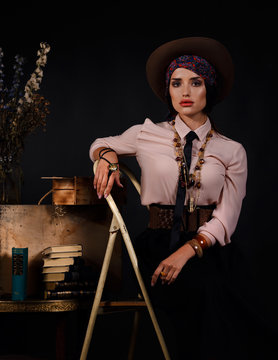 Model sitting on a ladder in a tie and Mexican style in studio