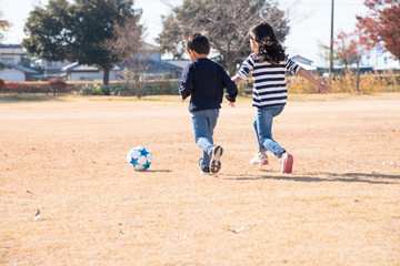 公園でサッカーをする子供