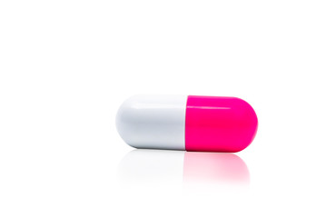 Pink, white capsule pills isolated on white background with shadow and copy space for text. Drug resistance concept. Antibiotics drug use with reasonable and global healthcare concept.