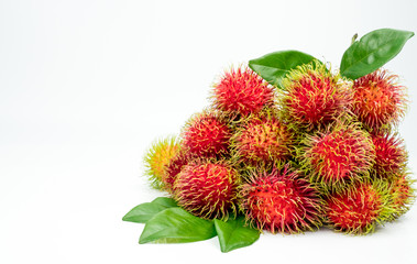 Fresh red ripe rambutan (Nephelium lappaceum) with leaves isolated on white background. Thai dessert sweet fruits.