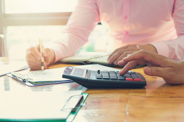 Business and finance concept of office working,Teamwork of Businessmen using calculator to discussing analysis Chart