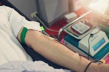 Nurse receiving blood from blood donor in hospital.
