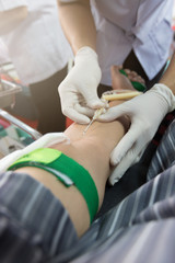 Nurse receiving blood from blood donor in hospital.