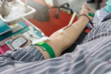 Nurse receiving blood from blood donor in hospital.