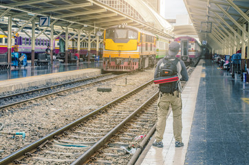Portrait of caucasian traveler standing on train station waiting for train