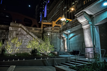 City stairs from riverwalk to bridge at night with moon in Chicago.
