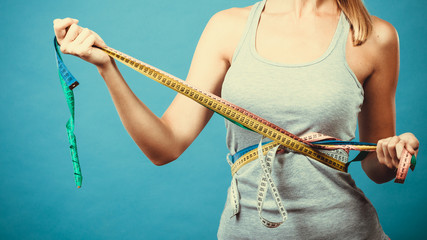 Fitness girl measuring her body with tapes