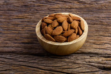 Group of Peeled almonds in wooden bowl