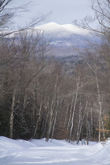 Snowmobile trail with view of snow covered Kennebago Mountain, Maine.