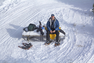Active senior man on snowshoes in Rangeley, Maine.
