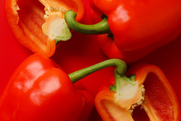 赤い背景の上に置かれた赤いパプリカ